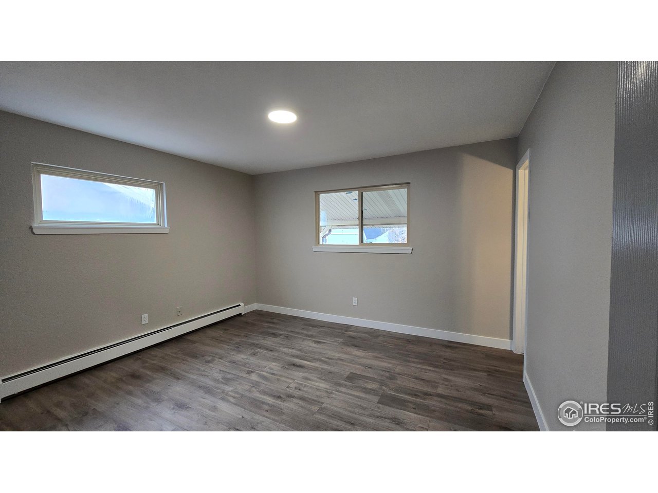 1312 Coolidge Street Sterling, CO 80751 - Photo 28 of 37 PRIMARY BEDROOM FROM HALLWAY, WINDOW ON LEFT FACES THE SIDE OF THE HOME, NORTH. WINDOW ON THE RIGHT FACES THE BACKYARD. YOU CAN SEE A LIGHT COMING THROUGH THE DOOR AT THE RIGHT OF THE WINDOW LEADING TO HALF BATH