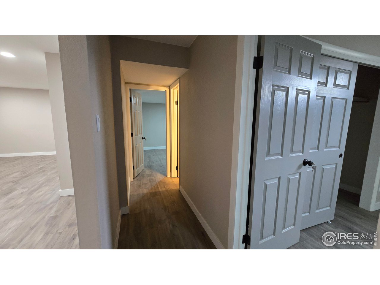 1312 Coolidge Street Sterling, CO 80751 - Photo 33 of 37 BASEMENT HALLWAY, FAMILY ROOM ON LEFT, LARGE BEDROOM AT THE FAR RIGHT, BRIGHT LIGHT IS COMING FROM 3/4 BATHROOM, AT THE END OF THE HALLWAY IS THE SMALLER BASEMENT BEDROOM WITH NO WINDOW