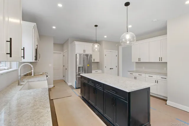 a large kitchen with kitchen island a sink stainless steel appliances and cabinets