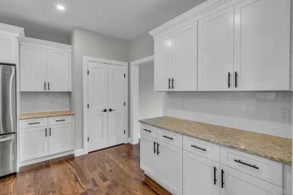 a kitchen with granite countertop white cabinets and white appliances