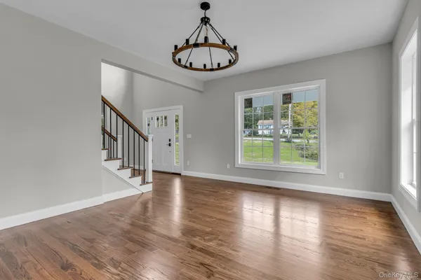 a view of empty room with wooden floor and window
