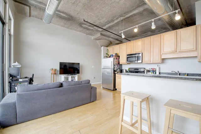 a kitchen with stainless steel appliances granite countertop a stove top oven a sink a dining table and chairs with white cabinets