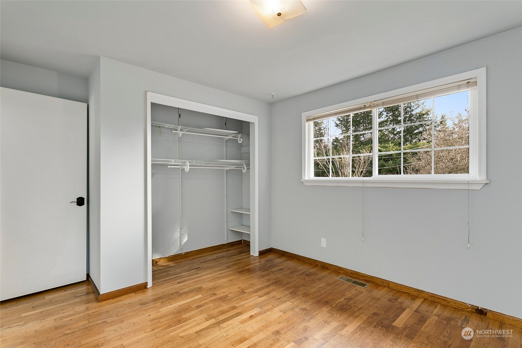 965 Hoquiam Avenue Northeast Renton, WA 98059 - Photo 16 of 37 an empty room with wooden floor cabinet and windows