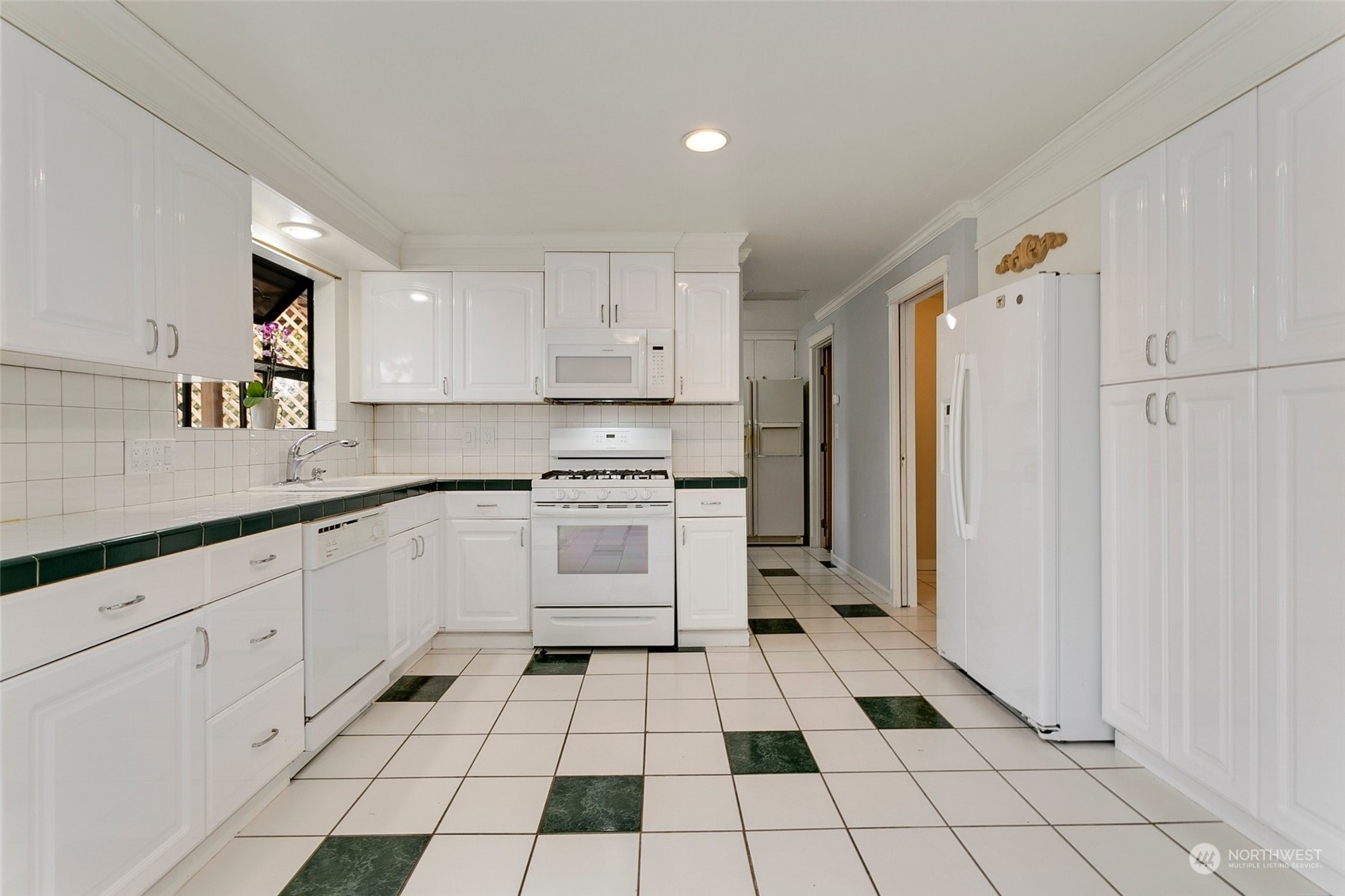 965 Hoquiam Avenue Northeast Renton, WA 98059 - Photo 10 of 37 a kitchen with white cabinets appliances and a sink