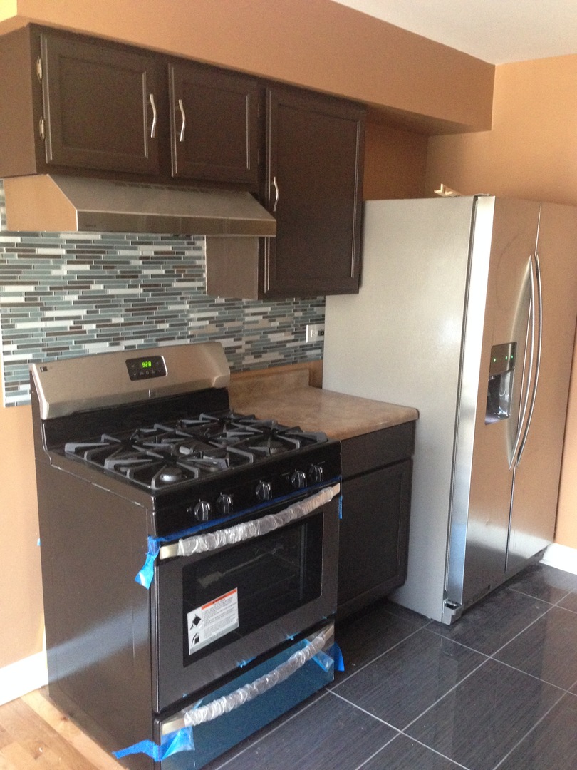 157 Peter Court, Unit D Bartlett, IL 60103 - Photo 4 of 16 a stove top oven sitting inside of a kitchen