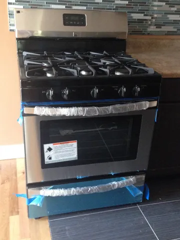 a stove top oven sitting inside of a kitchen