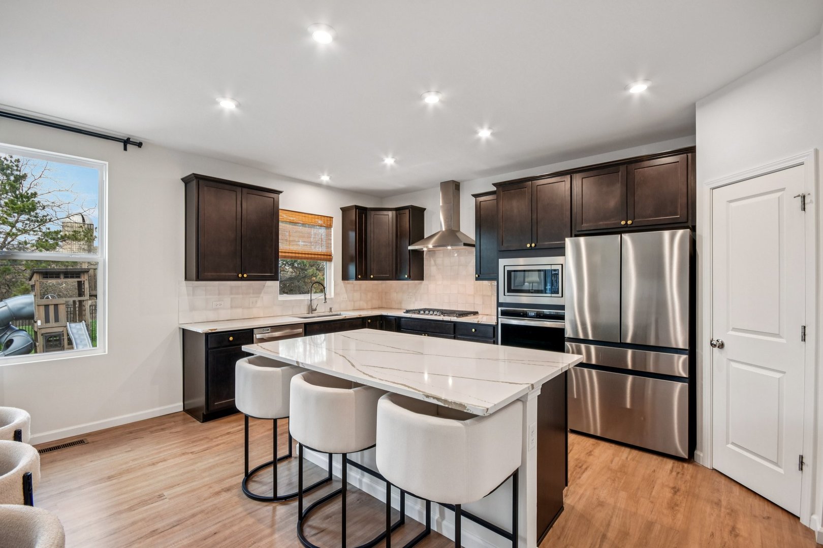600 Alpine Drive Algonquin, IL 60102 - Photo 11 of 40 a kitchen with stainless steel appliances granite countertop a refrigerator a stove top oven a sink dishwasher a dining table and chairs with wooden floor