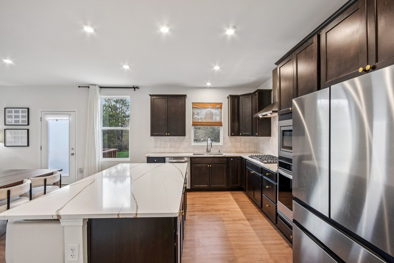 600 Alpine Drive Algonquin, IL 60102 - Photo 14 of 40 a large kitchen with stainless steel appliances kitchen island granite countertop a refrigerator a stove a sink dishwasher with a dining table and chairs