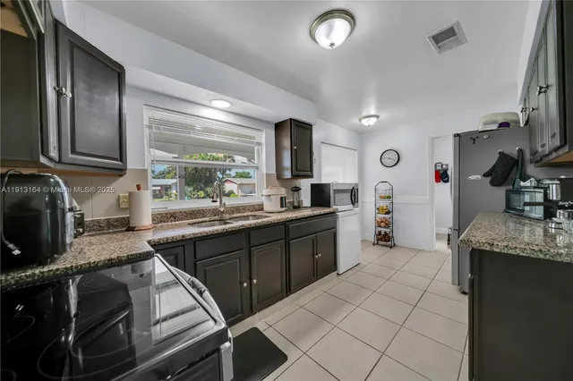 a kitchen with stainless steel appliances granite countertop a sink and stove