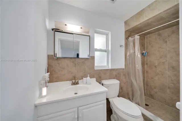 a bathroom with a sink toilet a mirror and shower