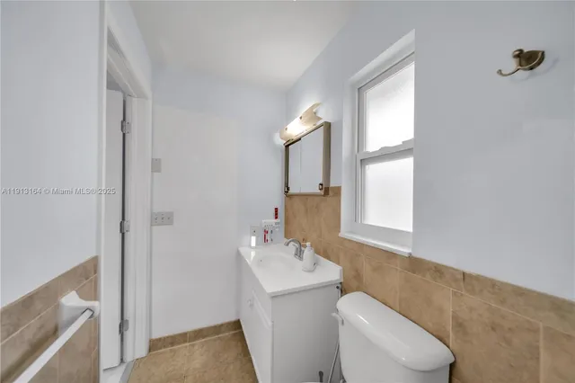 a bathroom with a toilet a sink and mirror