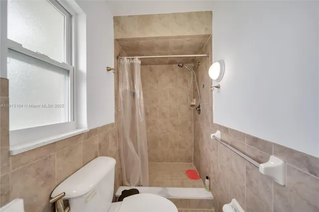 a bathroom with a toilet and a shower