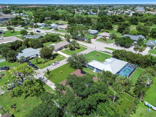 an aerial view of residential houses with outdoor space and street view