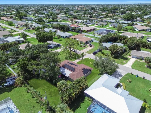 an aerial view of residential houses with outdoor space and trees