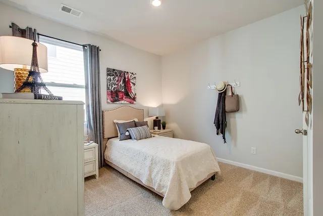 a bedroom with a bed and a large window