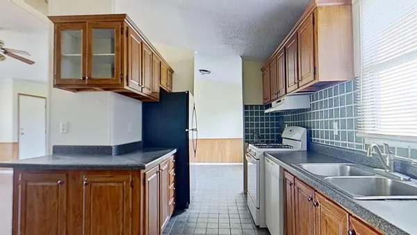 a kitchen with stainless steel appliances granite countertop a sink stove and cabinets