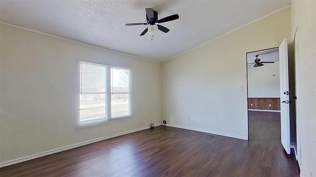 1106 Spring Flower Drive Krum, TX 76249 - Photo 14 of 22 an empty room with wooden floor ceiling fan and windows