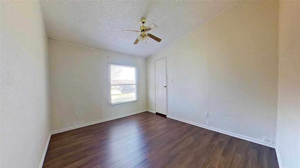 1106 Spring Flower Drive Krum, TX 76249 - Photo 15 of 22 wooden floor in an empty room with a window