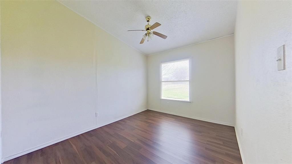 1106 Spring Flower Drive Krum, TX 76249 - Photo 17 of 22 an empty room with wooden floor chandelier fan and windows
