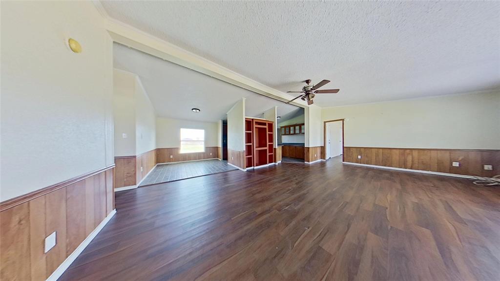 1106 Spring Flower Drive Krum, TX 76249 - Photo 6 of 22 a view of a livingroom with wooden floor staircase and a kitchen