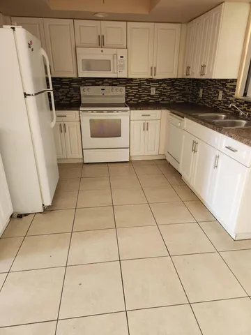 a kitchen with cabinets and white appliances