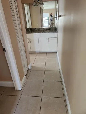 a bathroom with a granite countertop sink a toilet and mirror