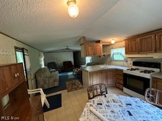 Kitchen featuring white range with gas cooktop and a textured ceiling