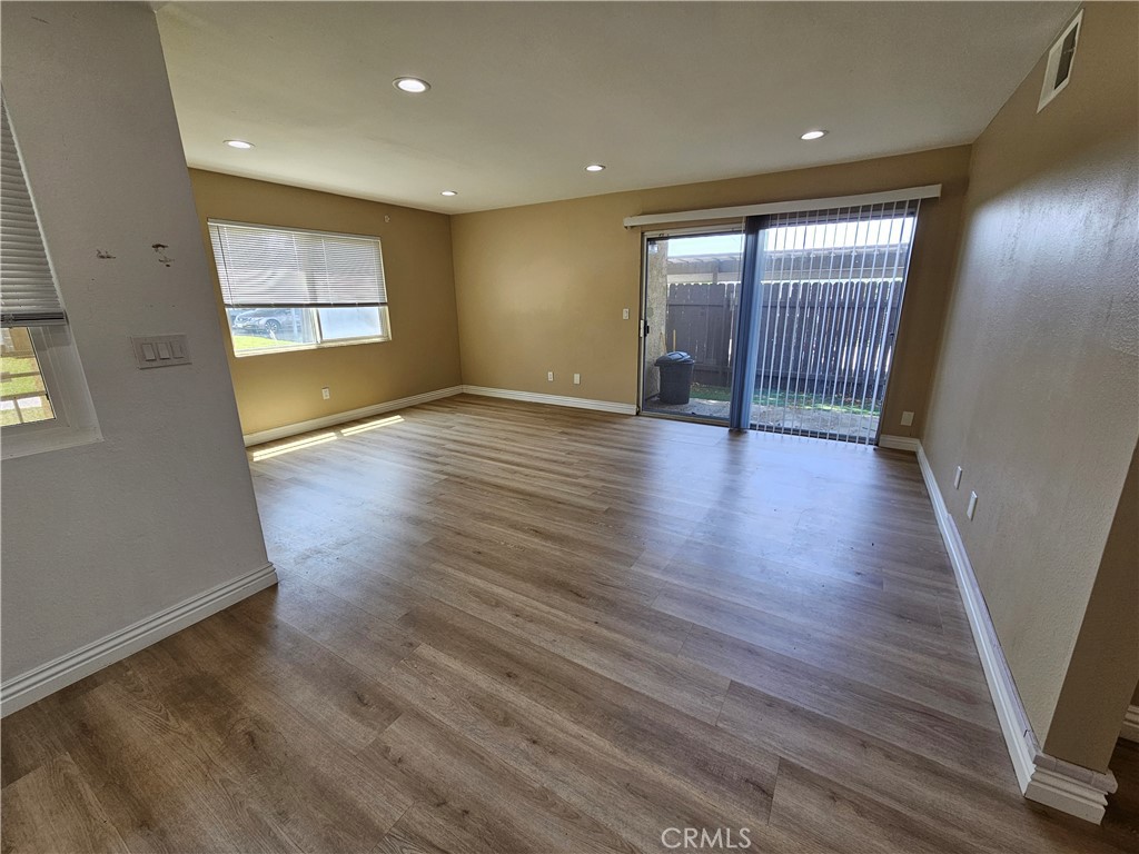 10976 Rincon Street Loma Linda, CA 92354 - Photo 3 of 12 an empty room with wooden floor and windows