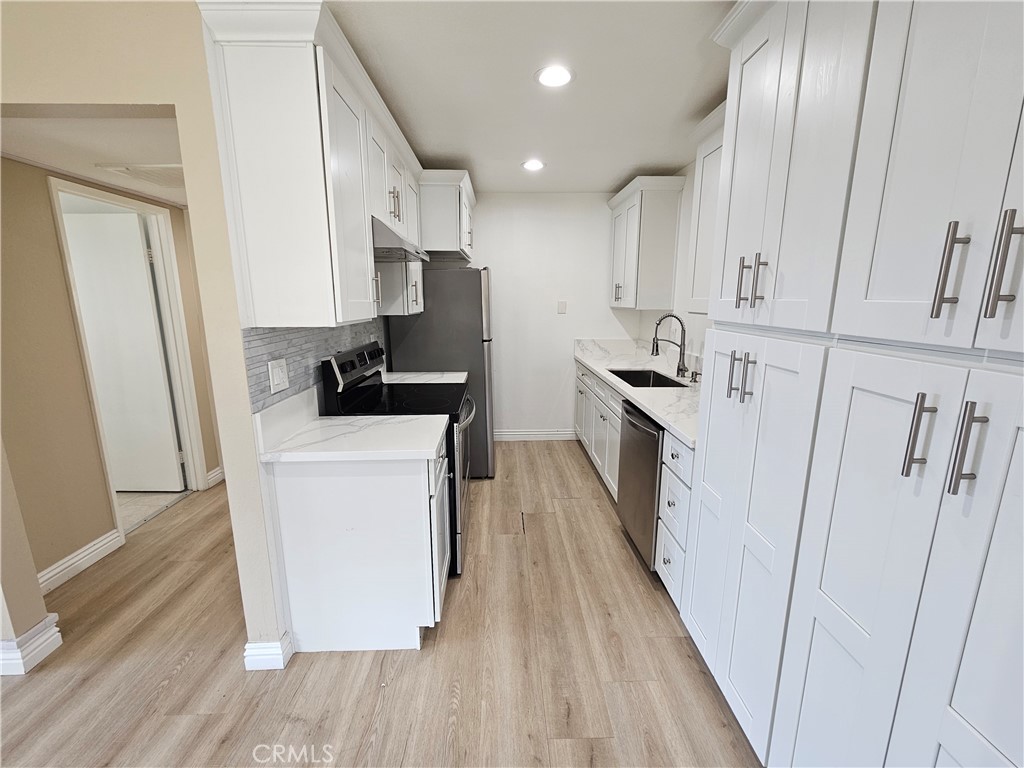 10976 Rincon Street Loma Linda, CA 92354 - Photo 6 of 12 a kitchen with sink a refrigerator and cabinets