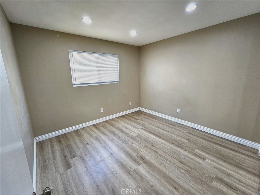 10976 Rincon Street Loma Linda, CA 92354 - Photo 10 of 12 an empty room with wooden floor and windows