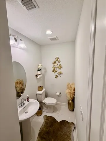 a bathroom with a sink toilet and mirror