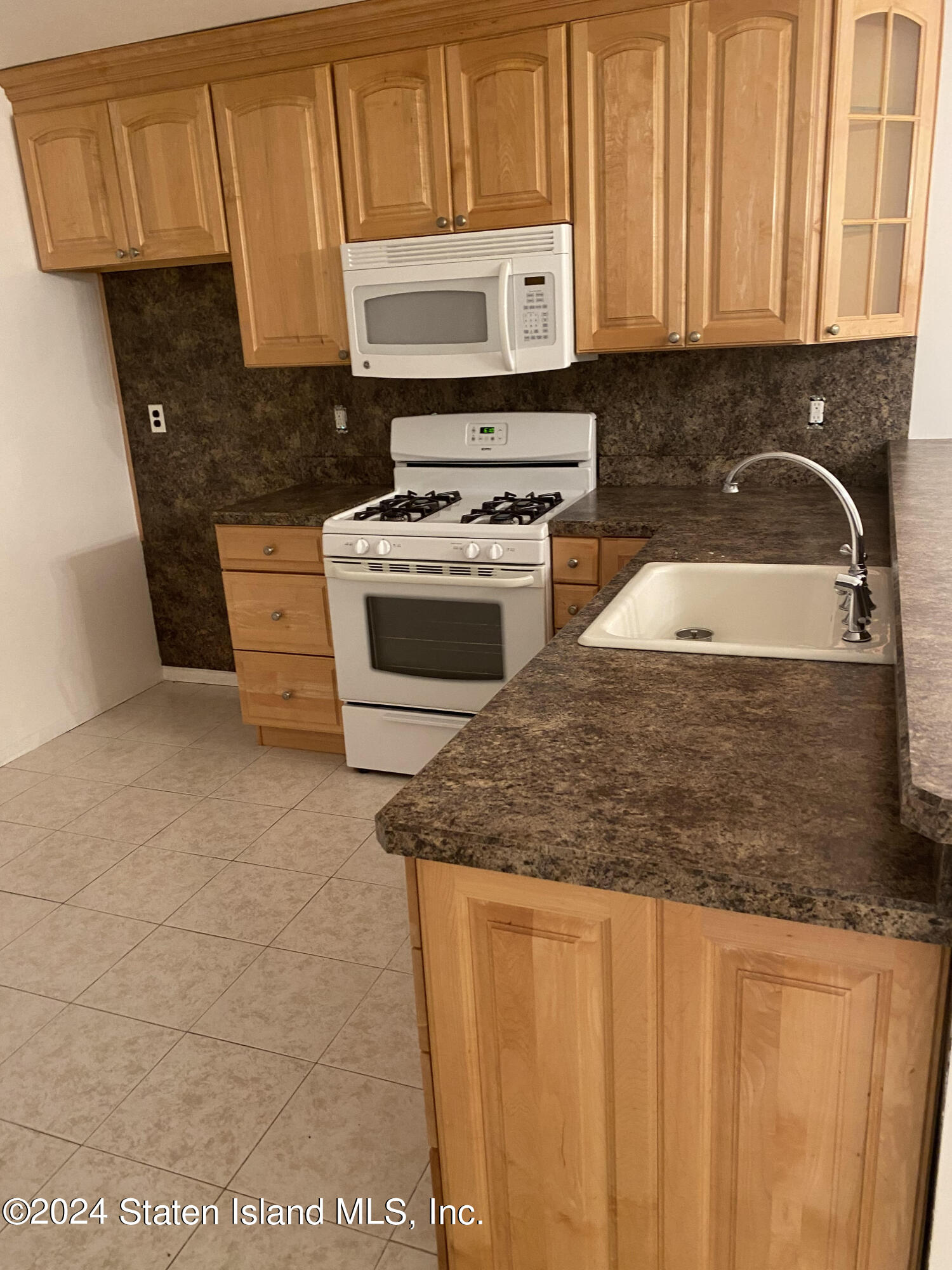26 Pembrook Loop Staten Island, NY 10309 - Photo 3 of 4 a kitchen with granite countertop a stove a sink and a microwave