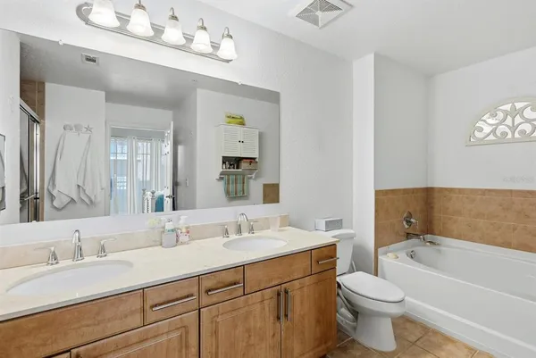 a bathroom with a toilet a sink a bathtub and a mirror