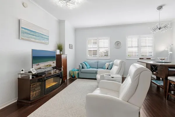 a living room with furniture a flat screen tv and a window