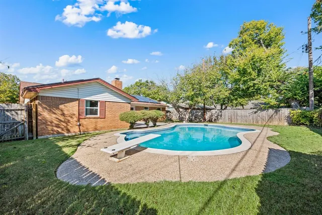 a view of a house with a backyard and swimming pool