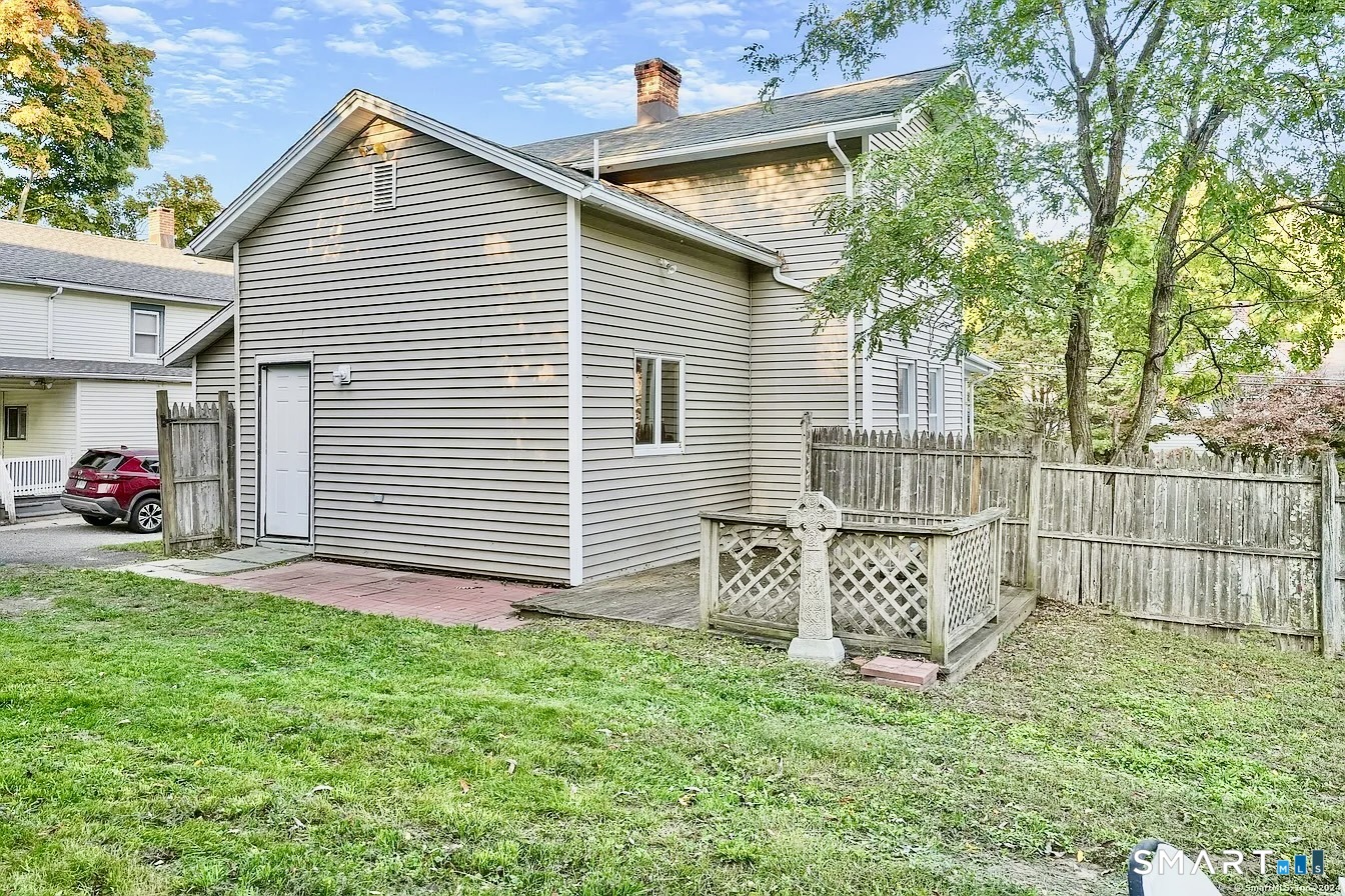 25 Pleasant Street Ansonia, CT 06401 - Photo 3 of 16 a white house with a small yard and a large tree