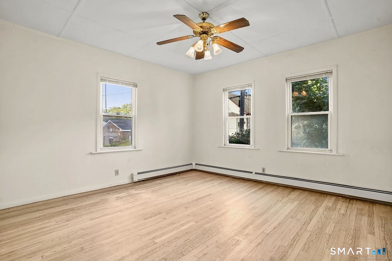 25 Pleasant Street Ansonia, CT 06401 - Photo 6 of 16 a view of an empty room with window and wooden floor