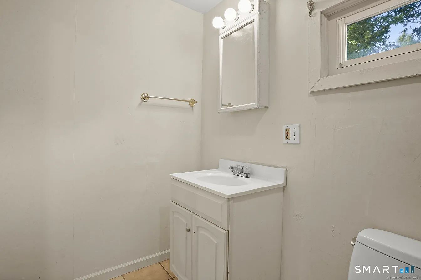 25 Pleasant Street Ansonia, CT 06401 - Photo 9 of 16 a bathroom with a sink a vanity and a window