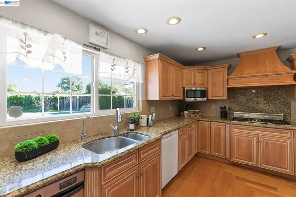a kitchen with stainless steel appliances granite countertop a stove and a refrigerator