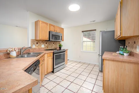 a kitchen with stainless steel appliances granite countertop a sink stove and cabinets