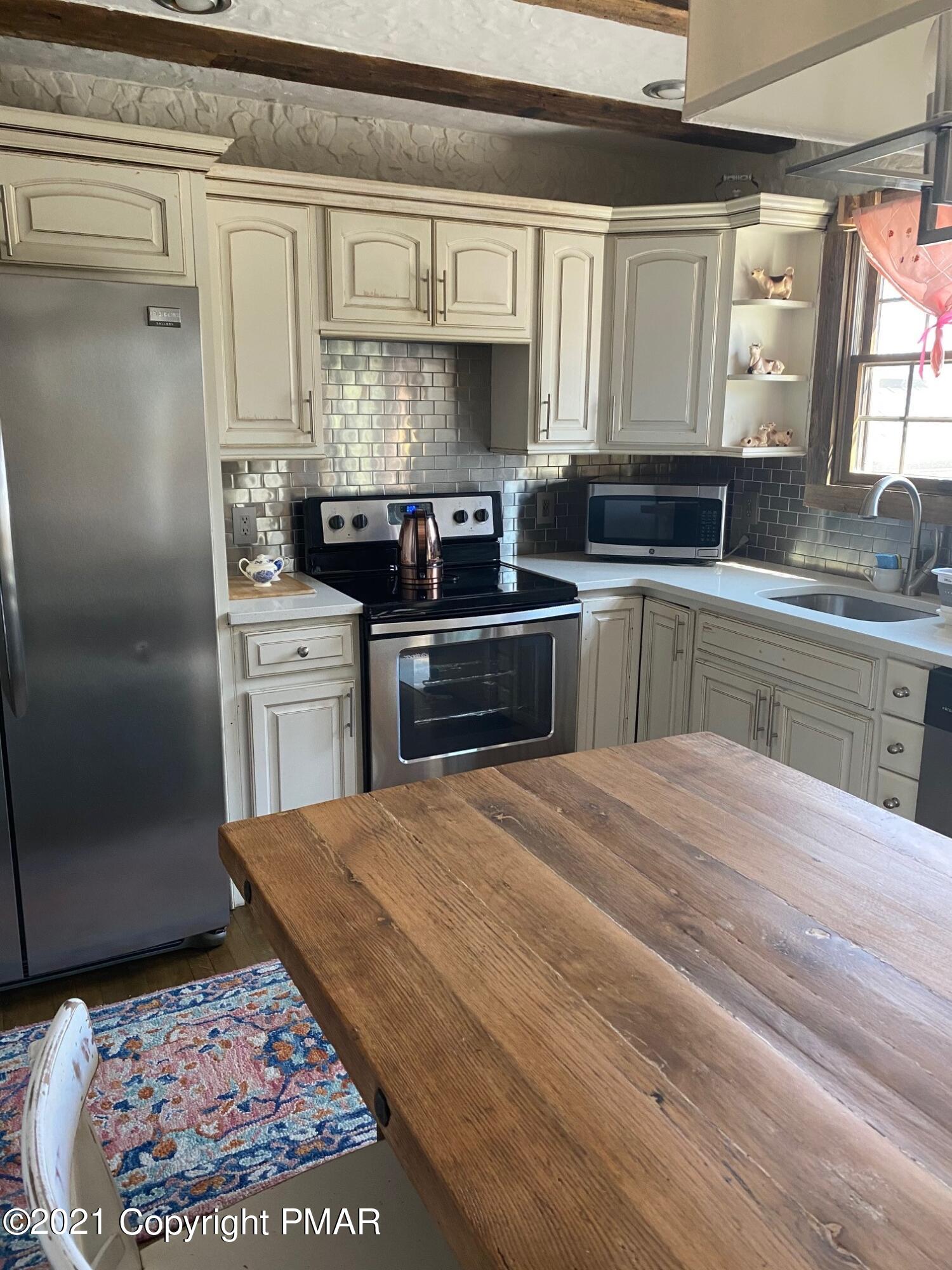 337 Tara Hill Road Bartonsville, PA 18321 - Photo 25 of 37 a kitchen with stainless steel appliances granite countertop a sink stove and cabinets