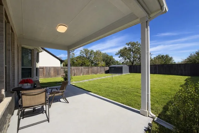a view of a chair and table in patio with a yard