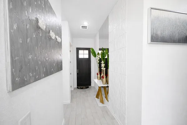 a view of a hallway with wooden floor and windows