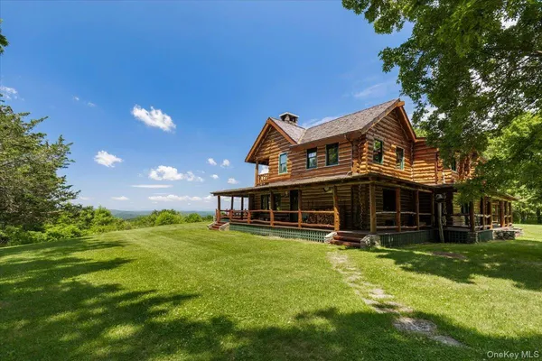 a view of a house with a big yard and large trees