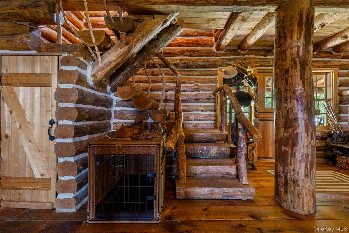 367 Prospect Hill Road Ancramdale, NY 12503 - Photo 27 of 50 Stairway featuring log walls, hardwood / wood-style floors, and a wooden ceiling with exposed beams