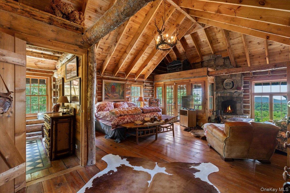 367 Prospect Hill Road Ancramdale, NY 12503 - Photo 29 of 50 Bedroom featuring hardwood / wood-style flooring, multiple windows, a wood ceiling with exposed beams, a fireplace, and high vaulted ceiling