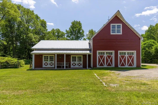 a view of a house with yard and trees in the background