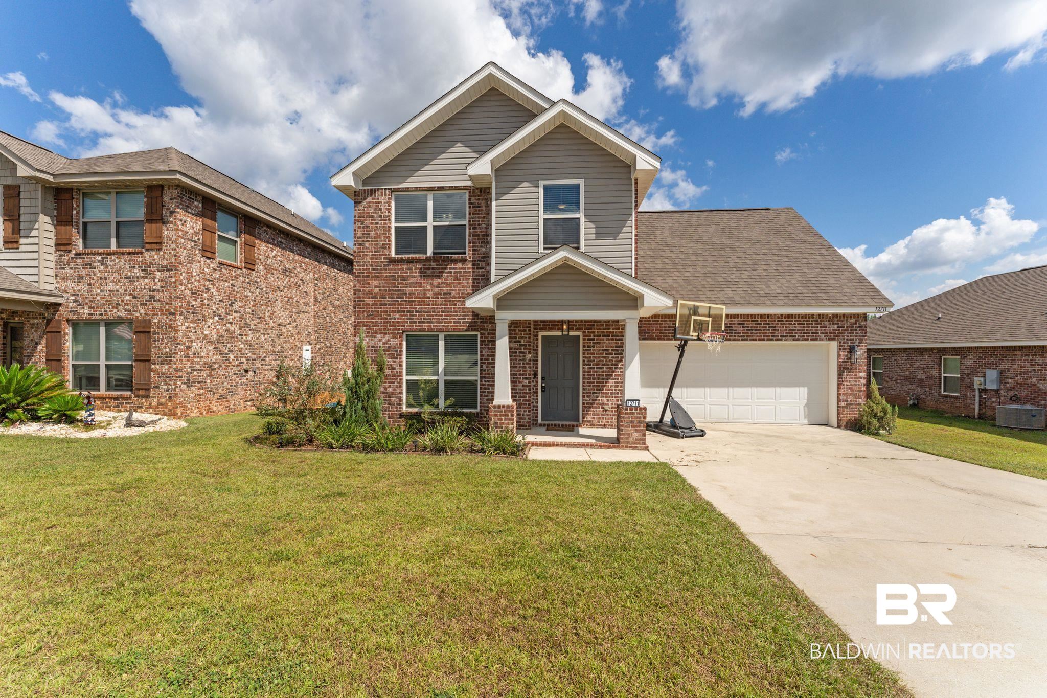 12711 Chickadee Lane Daphne, AL 36527 - Photo 1 of 39 View of front of home with a front lawn, concrete driveway, and brick siding