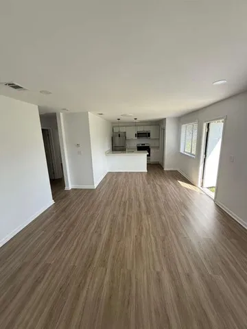 a view of a room with wooden floor and a window