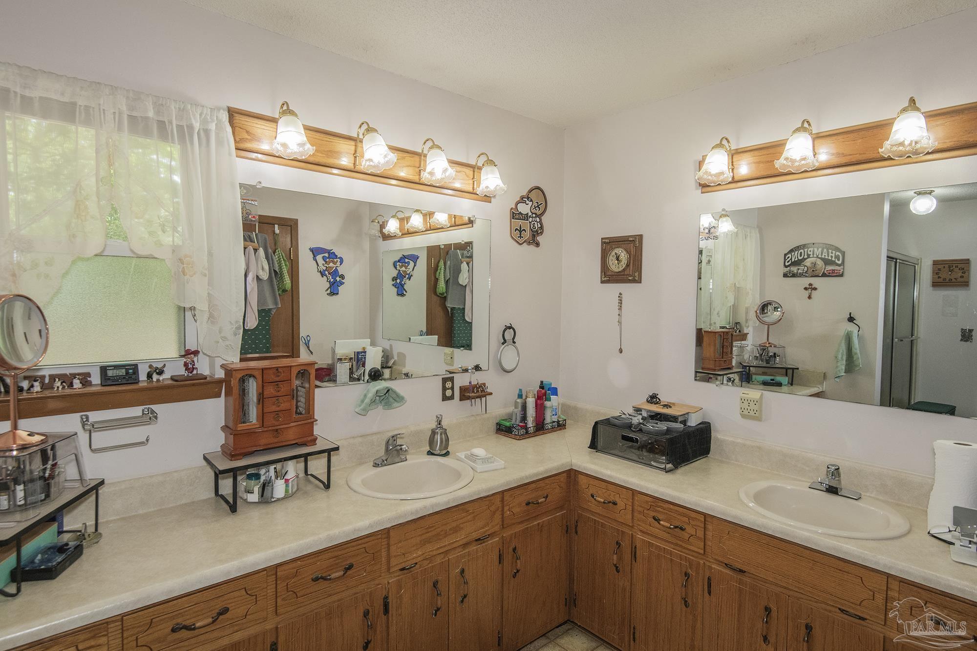 1210 Goldenrod Road Cantonment, FL 32533 - Photo 18 of 50 a bathroom with double vanity sinks and a mirror